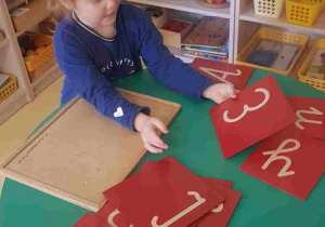 Dziewczynka podczas ćwiczeń z literami alfabetu