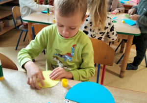 chłopiec robi ślimaka z kół origami