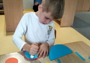 chłopiec robi ślimaka z kół origami