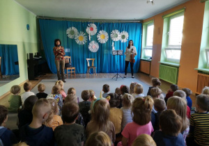 Dzieci oglądają i słuchają występujących na scenie artystów