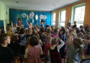 Dzieci wraz z artystami tańczą do utworu muzycznego