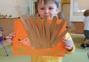 Chłopiec trzyma w dłoniach swoją pracę plastyczną pt. "Jeż Kolczatek"