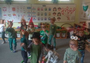 Dzieci pozują do zdjęcia w czapeczkach i maskach na głowach