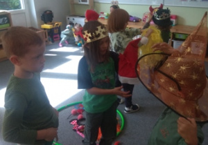 Dzieci podczas zabawy ruchowej w czapeczkach i maskach na głowach