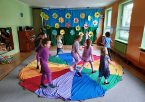 Dzieci podczas zabawy ruchowej chodzą po chuście animacyjnej