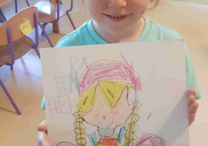 Dziewczynka prezentuje rysunek anioła