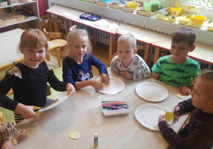 Dzieci starsze ćwiczą wycinanie aniołów z papierowego talerza