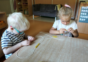 dzieci nawlekają makaron na sznurek
