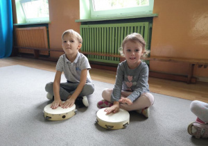 Chłopiec i dziewczynka grają na tamburynach
