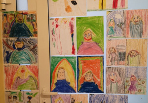 Zdjęcie przedstawia wiszące na drzwiach portrety pań z grupy II namalowane przez dzieci