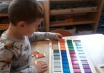 Chłopiec układa tabliczki barwne