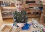 Chłopiec układa drewniane cylindry
