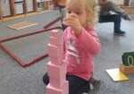 dziewczynka układa różową wieżę