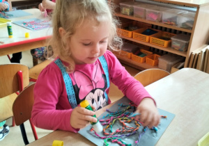 dziewczynka tworzy abstrakcję z włóczki