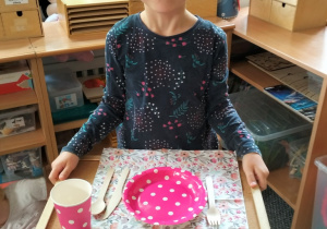 dziewczynka prezentuje swoje nakrycie do stołu