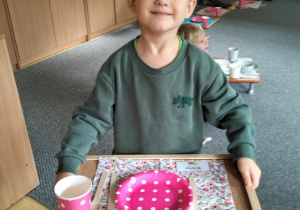 chłopiec prezentuje swoje nakrycie do stołu