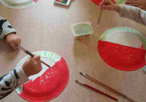 Dzieci malują białe kropki na kapeluszach muchomorów