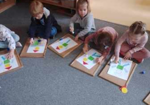 Dzieci utrwalają kształty znaków drogowych poprzez układanie kompozycji z figur geometrycznych
