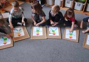 Grupa dzieci podczas zabawy dydaktycznej utrwalającej kształty znaków drogowych