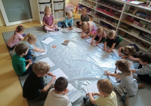 Dzieci w trakcie grupowej zabawy plastycznej
