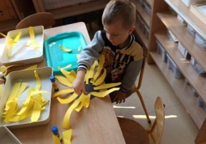 Chłopiec podczas przyklejania żółtych pasków
