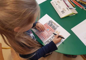 Dziewczynka szkicuje budynek główny Manufaktury