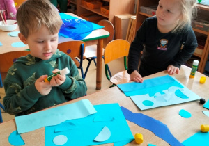 dzieci tworzą pracę w odcienaich koloru niebieskiego