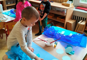 dzieci tworzą pracę w odcienaich koloru niebieskiego
