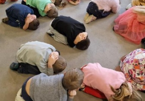 Dzieci podczas ćwiczeń przyjmowania pozycji obronnej - "żółwia"
