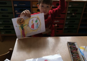 Chłopiec prezentuje wykonany rysunek