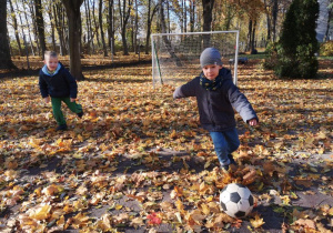 Dwóch chłopców gra w piłkę nożną na boisku