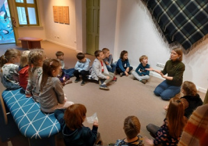 Zdjęcie przedstawia przedszkolaków słuchających ciekawostek o tkaninach