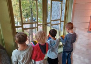 Dzieci oglądają kolorowe witraże w świetle dziennym