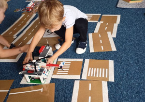 Chłopiec układa makietę Pogotowie z klocków Lego