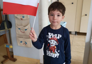 Chłopiec pozuje z wykonaną przez siebie flagą