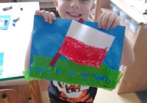 Chłopiec z uśmiechem trzyma flagę