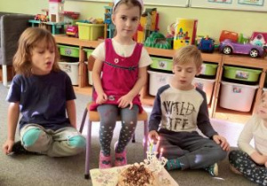 Nina myśli nad życzeniem przed zdmuchnięciem świeczek urodzinowych
