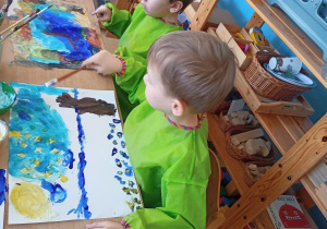 Dwóch chłopców maluje farbami