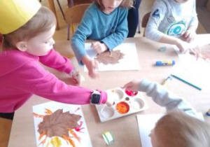 Dzieci maczają palce w farbie