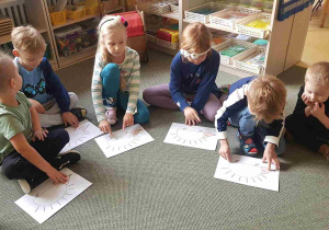 Dzieci słuchają muzyki z wykorzystaniem ilustracji jeża