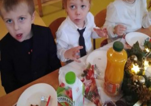 Dzieci jedzą różne smakołyki podczas Uroczystości Wigilijnej