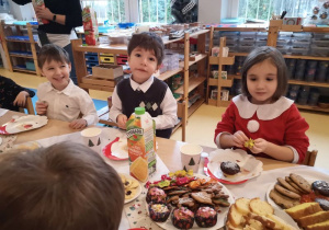 Dzieci siedzą przy stole podczas Uroczystości Wigilijnej