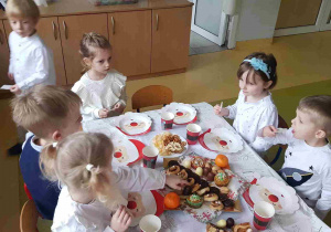Dzieci siedzą przy wspólnym świątecznym stole