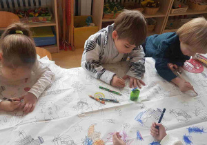 Dzieci kolorują obrazki na świątecznym obrusie