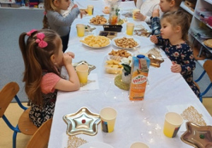Dzieci siedzą przy stole wigilijnym