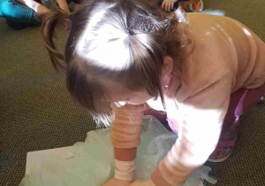 Dziewczynka przykleja chmurkę wykonaną z kawałków folii