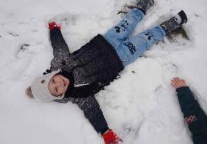Chłopiec na śniegu robi aniołka