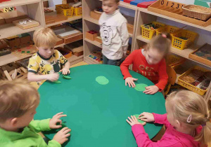 Dzieci składają zielone koła na pół