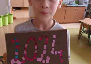 Chłopiec prezentuje wyklejony z błyszczącego papieru napis "2024"