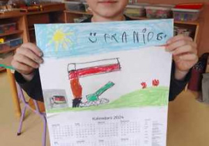 Franio trzyma w dłoniach narysowany przez siebie noworoczny kalendarz